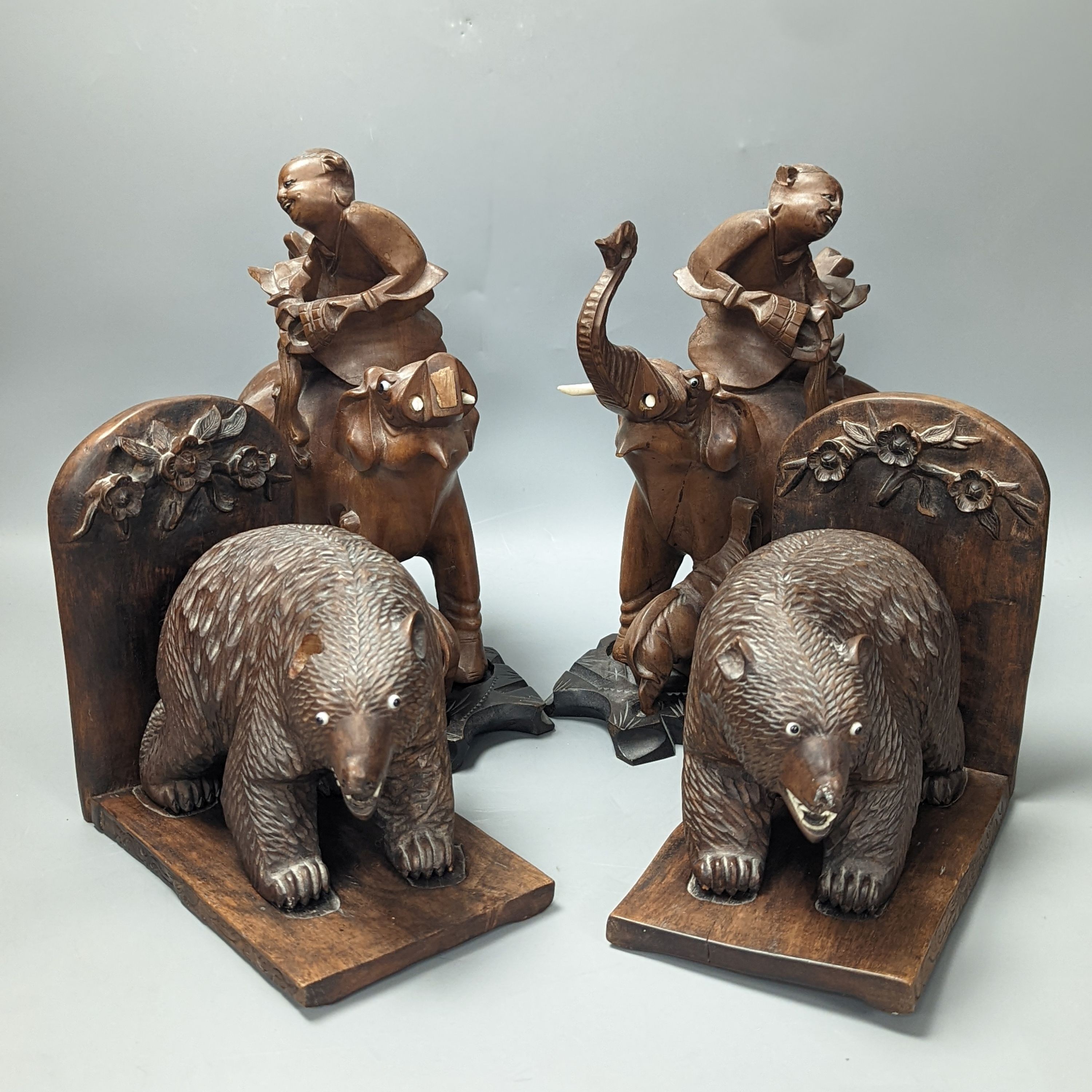 A pair of Chinese wood carvings figures on elephants, a pair of Chinese bear bookends, Chines figures 26 cms high.